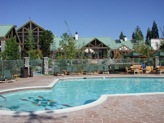 A large swimming pool with a lodge in the background